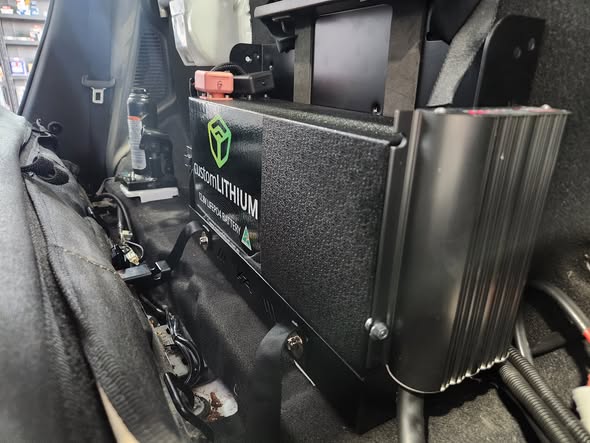 A CustomLITHIUM dual battery and DC-DC charger installed behind the seat of a four-wheel drive