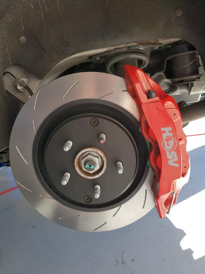 A slotted brake rotor and red six-piston HSV caliper freshly fitted