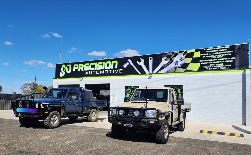 The SNJ Precision Automotive shopfront on Percy Street, with the black and green sign and two customer four-wheel drives parked out front